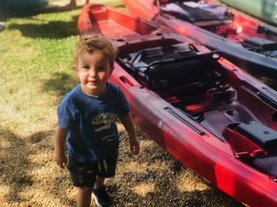 Thomas stands outside next to boats