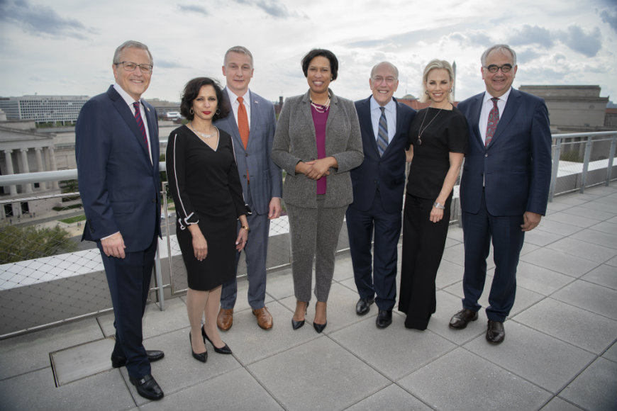 Press conference leaders and speakers pose for a photo with the Washington Monument in the background.