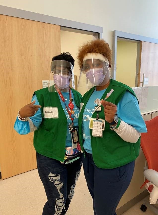 Chrystal Young-Johnson joins a school nurse at a COVID-19 vaccination event at Children's National THEARC