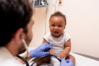 Baby sitting on exam table