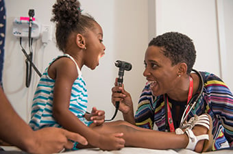 Provider checking girl's tonsils