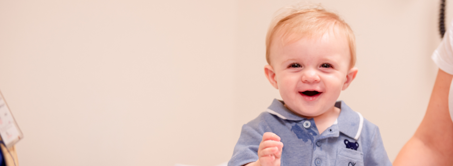 smiling baby on exam table