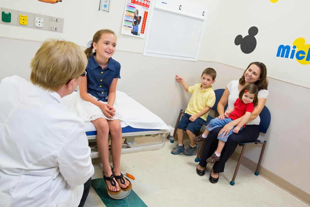 Mom and kids in exam room with doctor