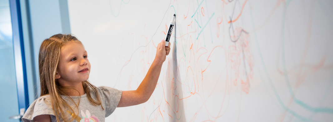 girl drawing on whiteboard