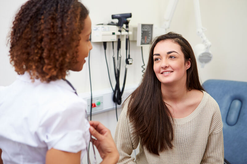 A teenage girl talks to her healthcare provider.