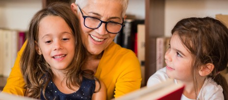 A woman reading to two little girls