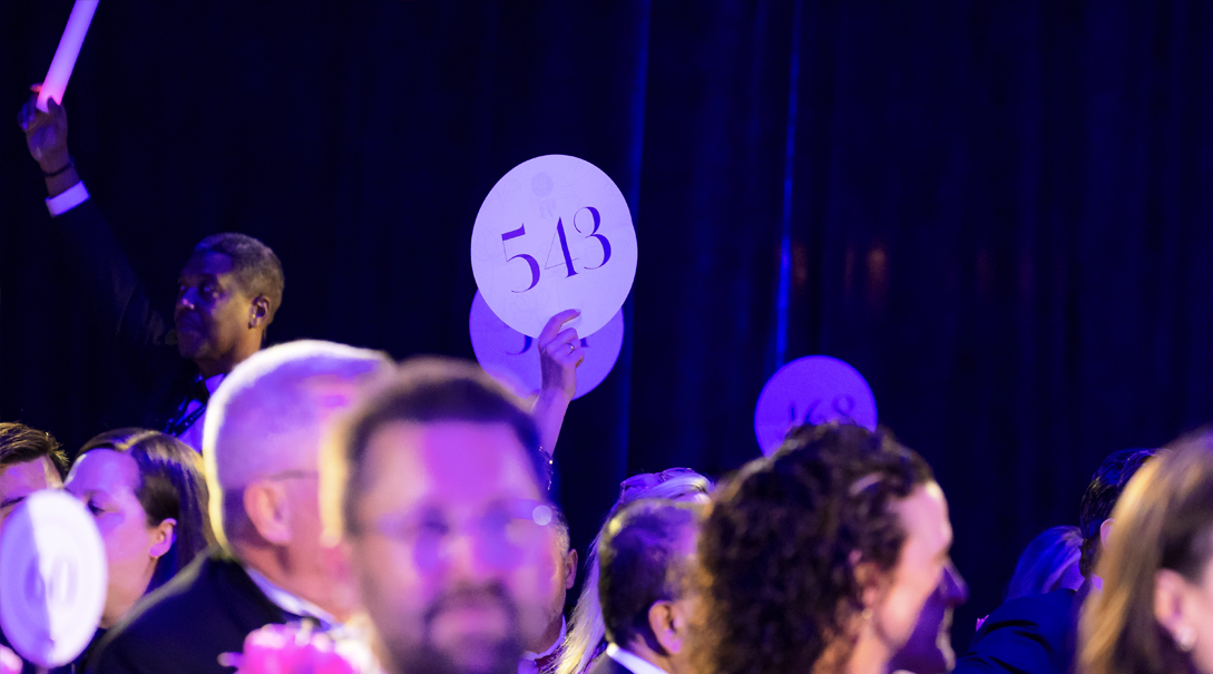 A bidder raises their paddle at the Children's Ball.