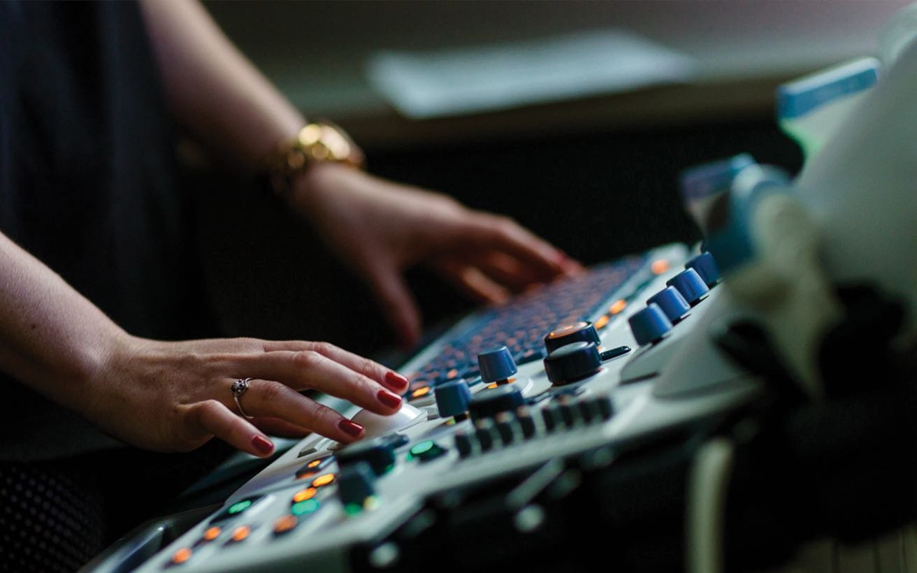 An ultrasound technician at the controls.