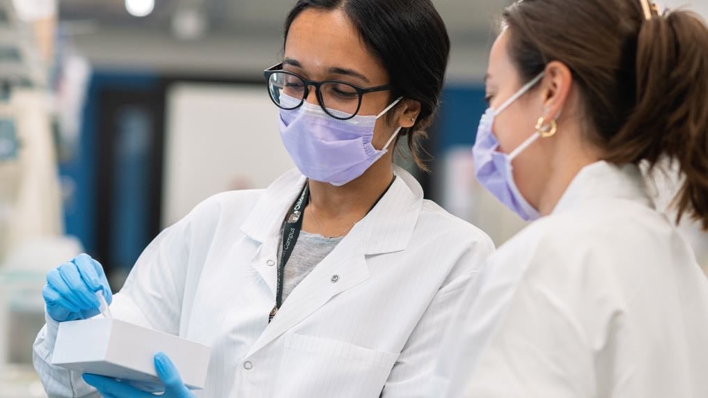 Two female researchers confer.