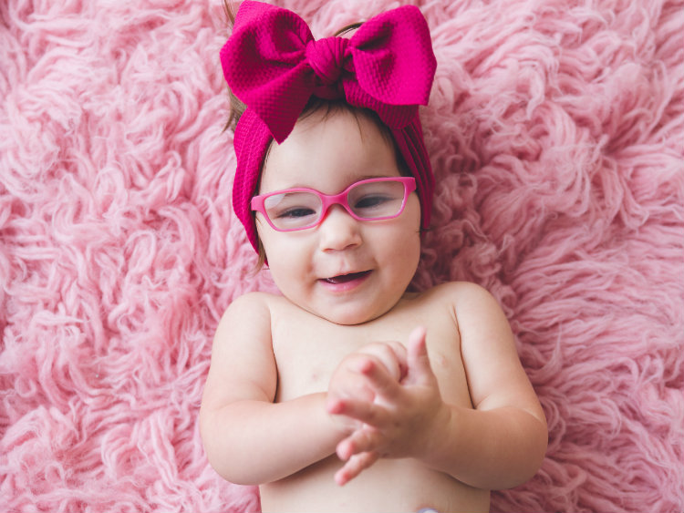 Baby Bella wearing a pink bow and clapping