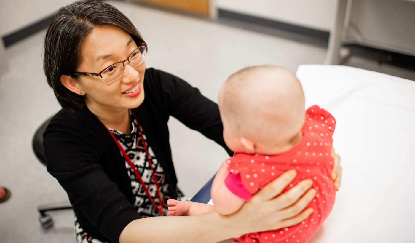 Photo of East Asian doctor with an infant patient.