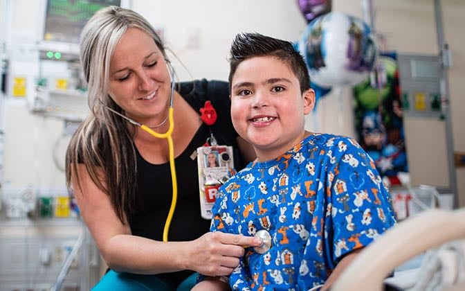 A neprhology specialist examines a pre-teen kidney patient.