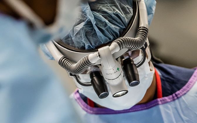 A close-up shot of a surgeon performing surgery wearing a scope.