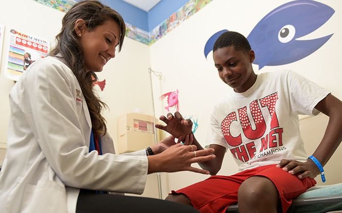 An orthopaedic specialist examines a teen patient.