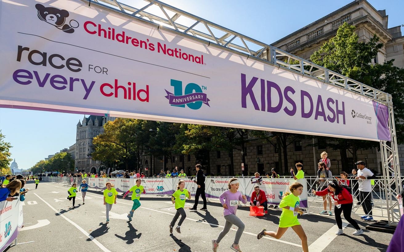 Runners cross the finish line at The Race for Every Child road race.