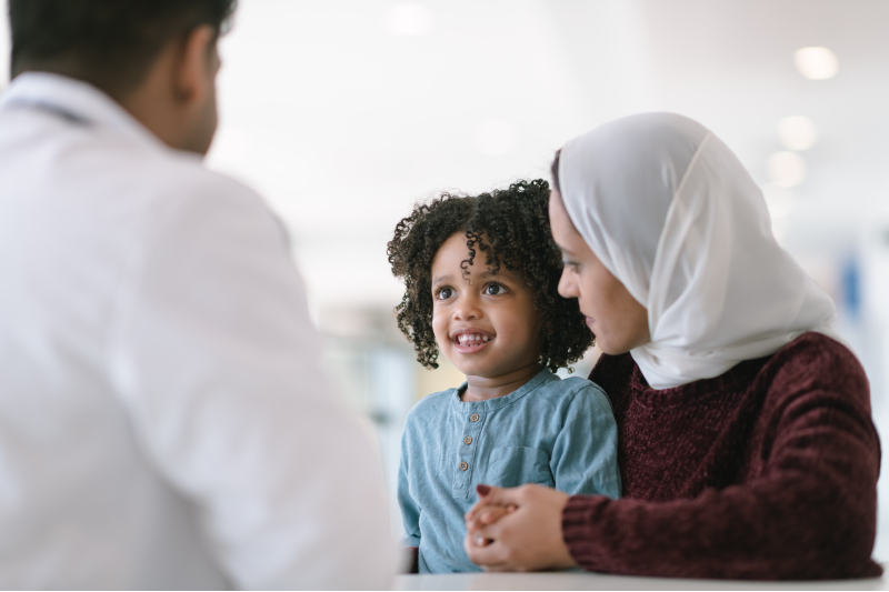 Woman holding a child talking to a provider.