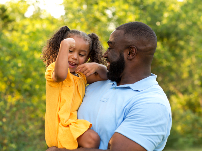 father holds happy little girl