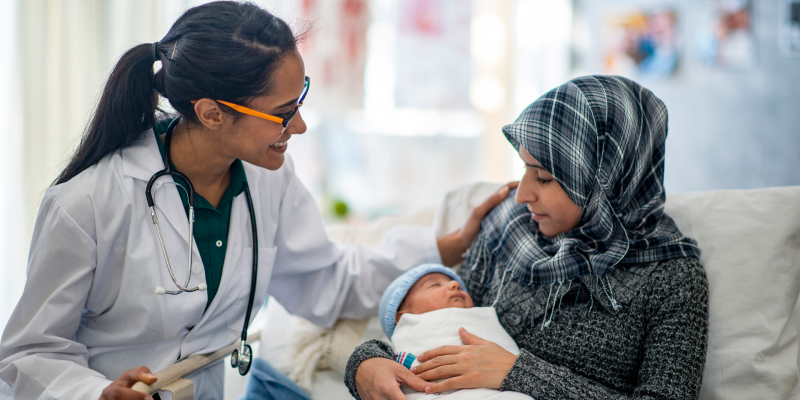 doctor interacts with mother holding infant