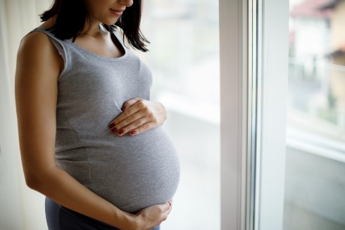 A pregnant woman holding her belly.