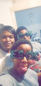 Messiah, his mother, and his brother wearing 2003 new year's glasses.