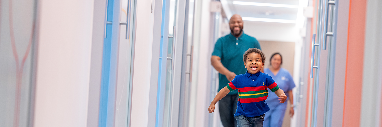 Young boy running down the hallway. 