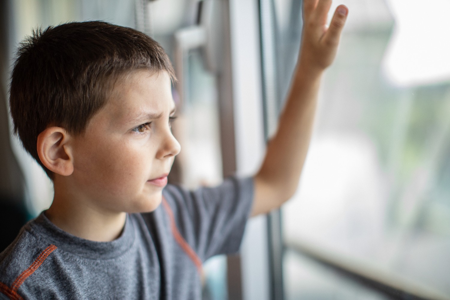 A boy looking outside the window. 