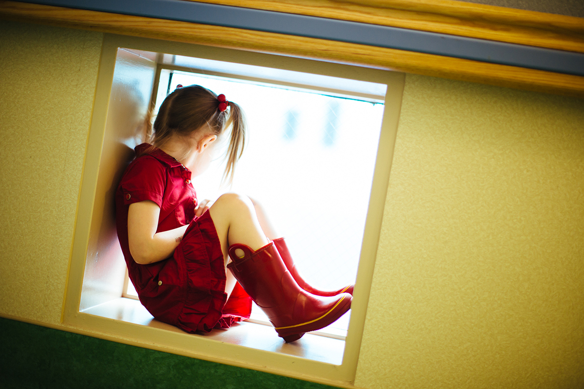Girl in red dress sitting in window