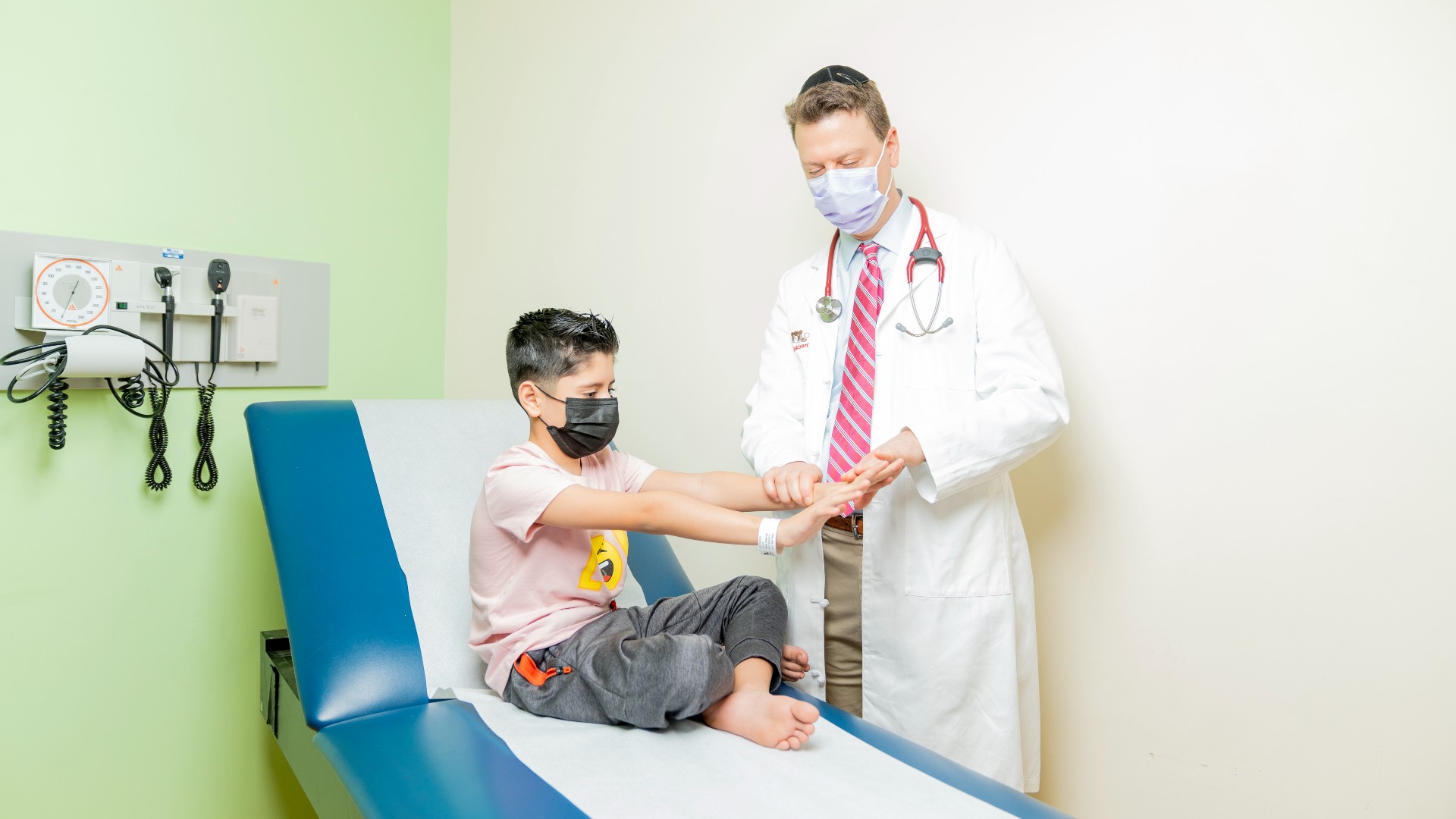 Provider performing a strength exam on a young boy