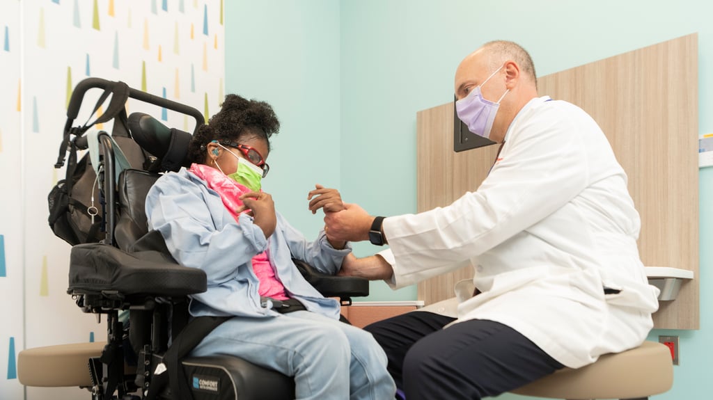 doctor examines young girl in wheelchair