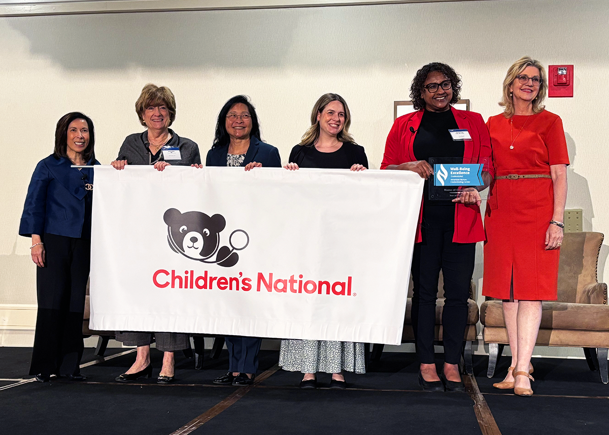 Children's National nurses at ANCC event holding a banner