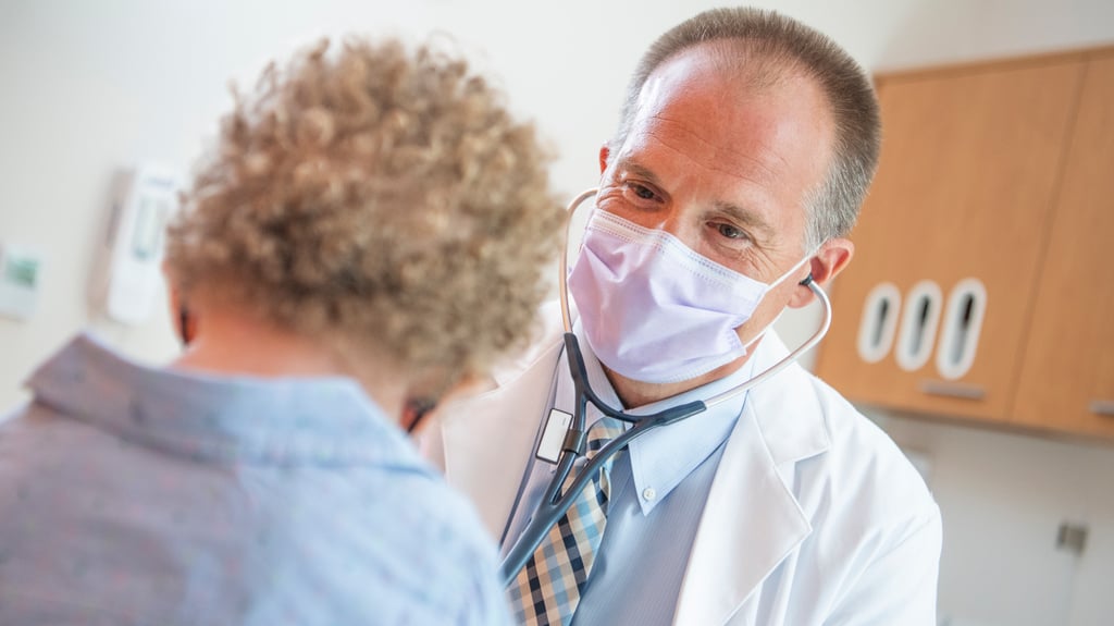 Doctor wearing mask examines patient
