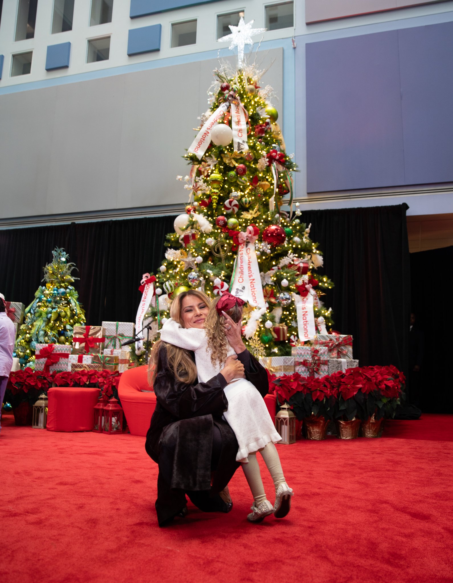 The First Lady being hugged by a little girl.
