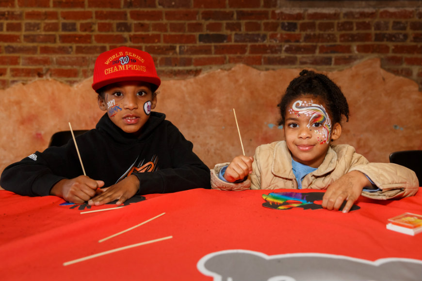 Boy and girl smile while drawing and painting together at craniofacial party.