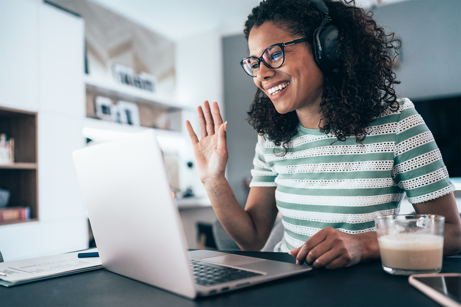 Woman on a virtual meeting waving to the camera