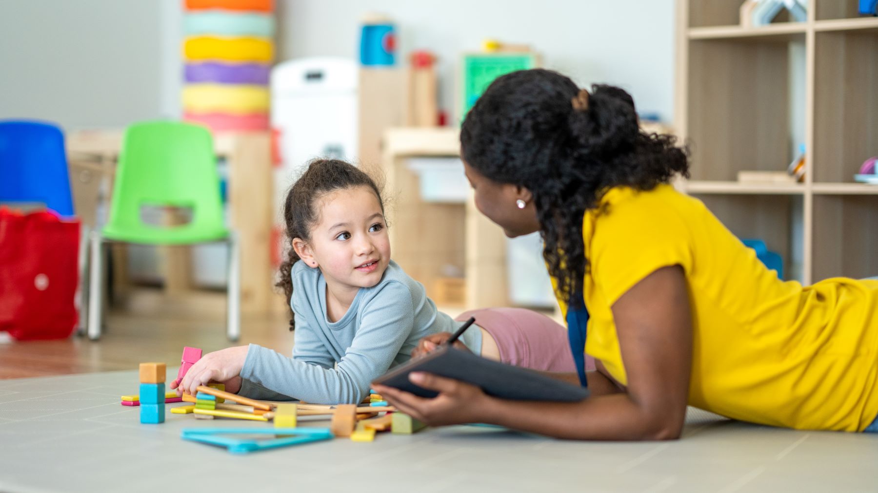 female psychiatry provider and young girl play with blocks