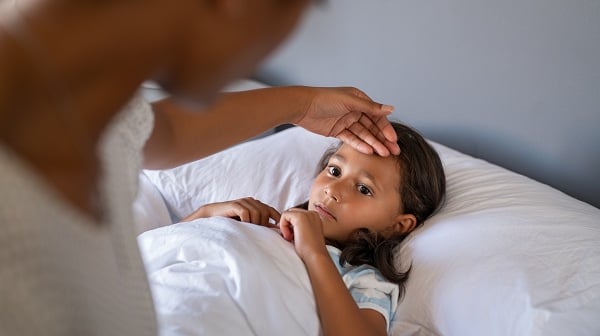 Mom checks sick child's forehead