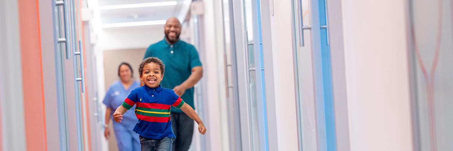 Young boy running down hallway smiling