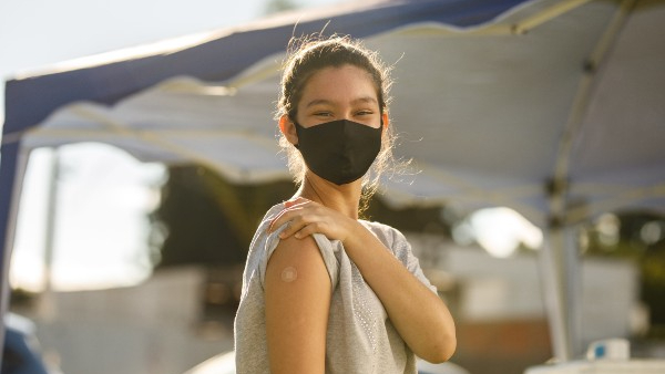 child shows bandaid on her arm