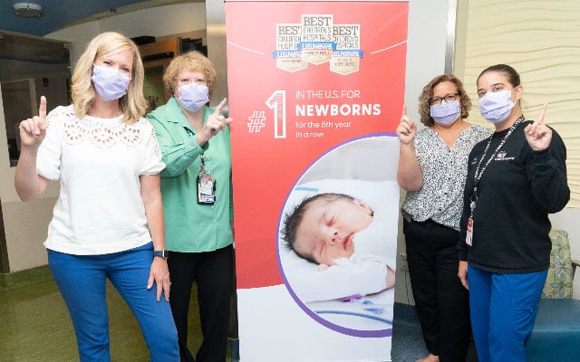 Providers standing in front of a banner celebrating Children's National Hospital ranking number one nicu