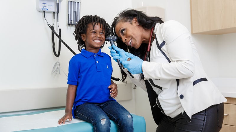 Female doctor checking a child's ear