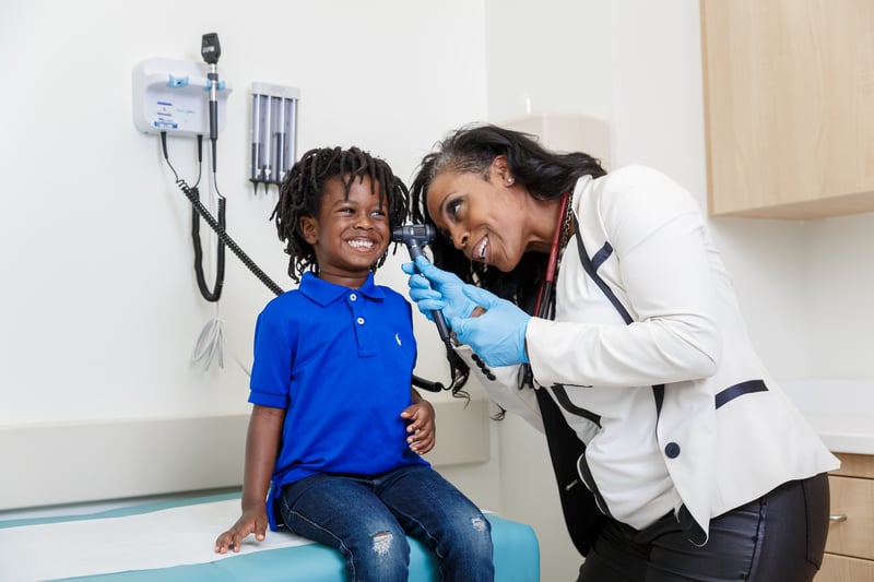 Female doctor checking a child's ear