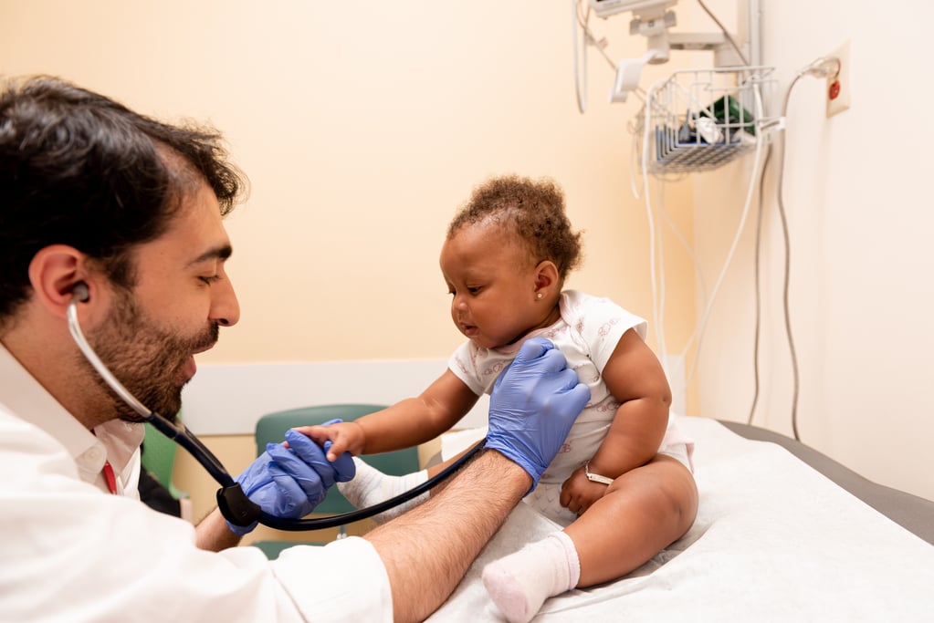 Male doctor using a stethoscope on a baby