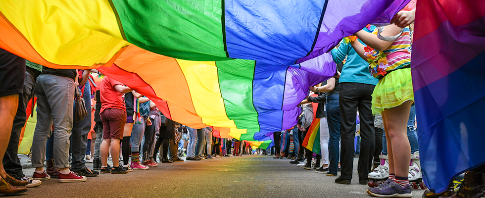 People under a rainbow parachute