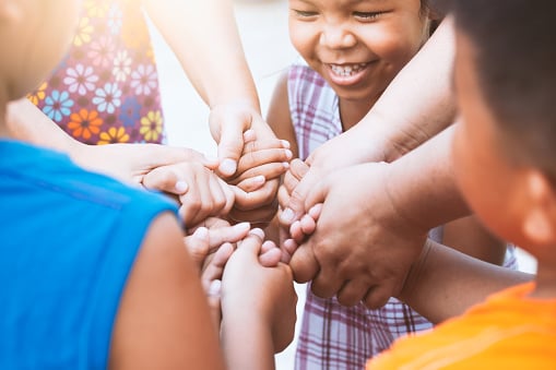 Kids with hands in a circle