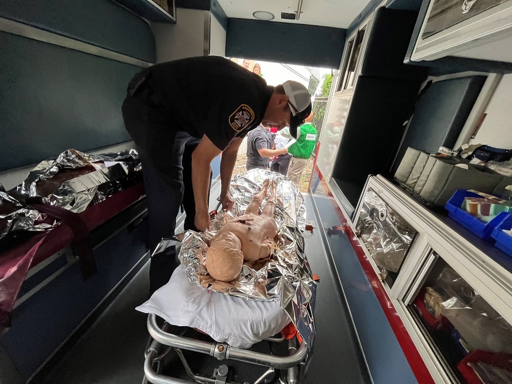 EMS team member with a patient mannequin in an ambulance