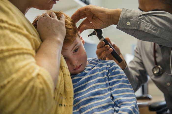 A boy getting his ear checked.
