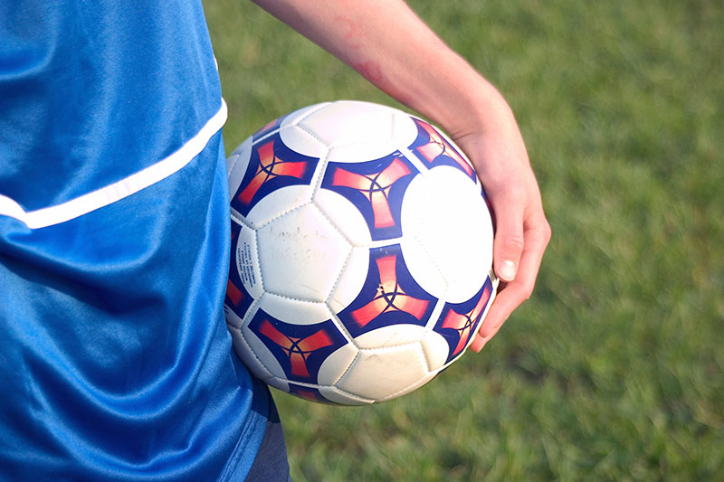 child holding soccer ball