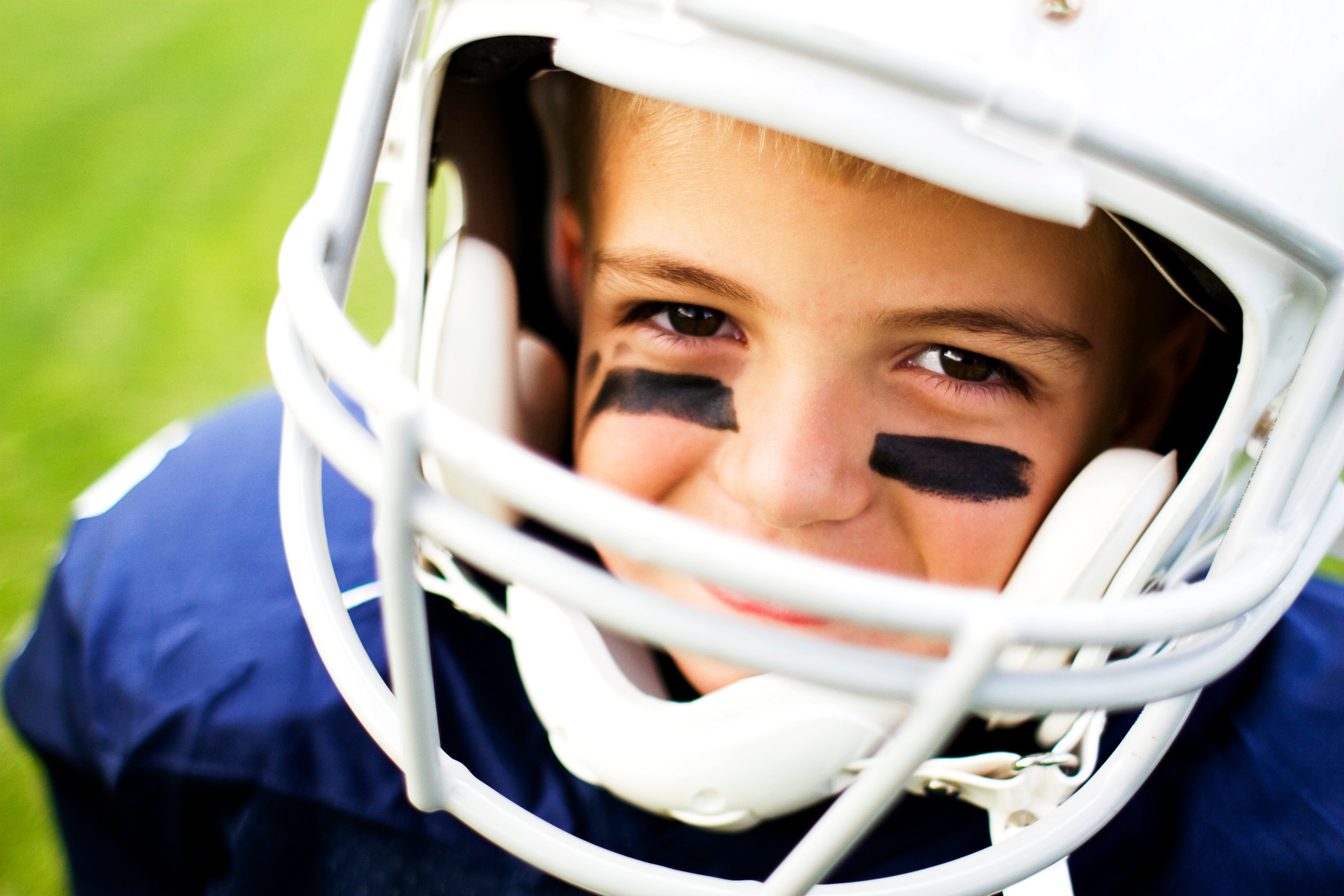 Boy wearing a football helmet.
