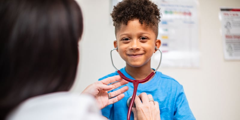 Young Boy Trying Provider's Stethoscope and Listening to His Own Heartbeat.