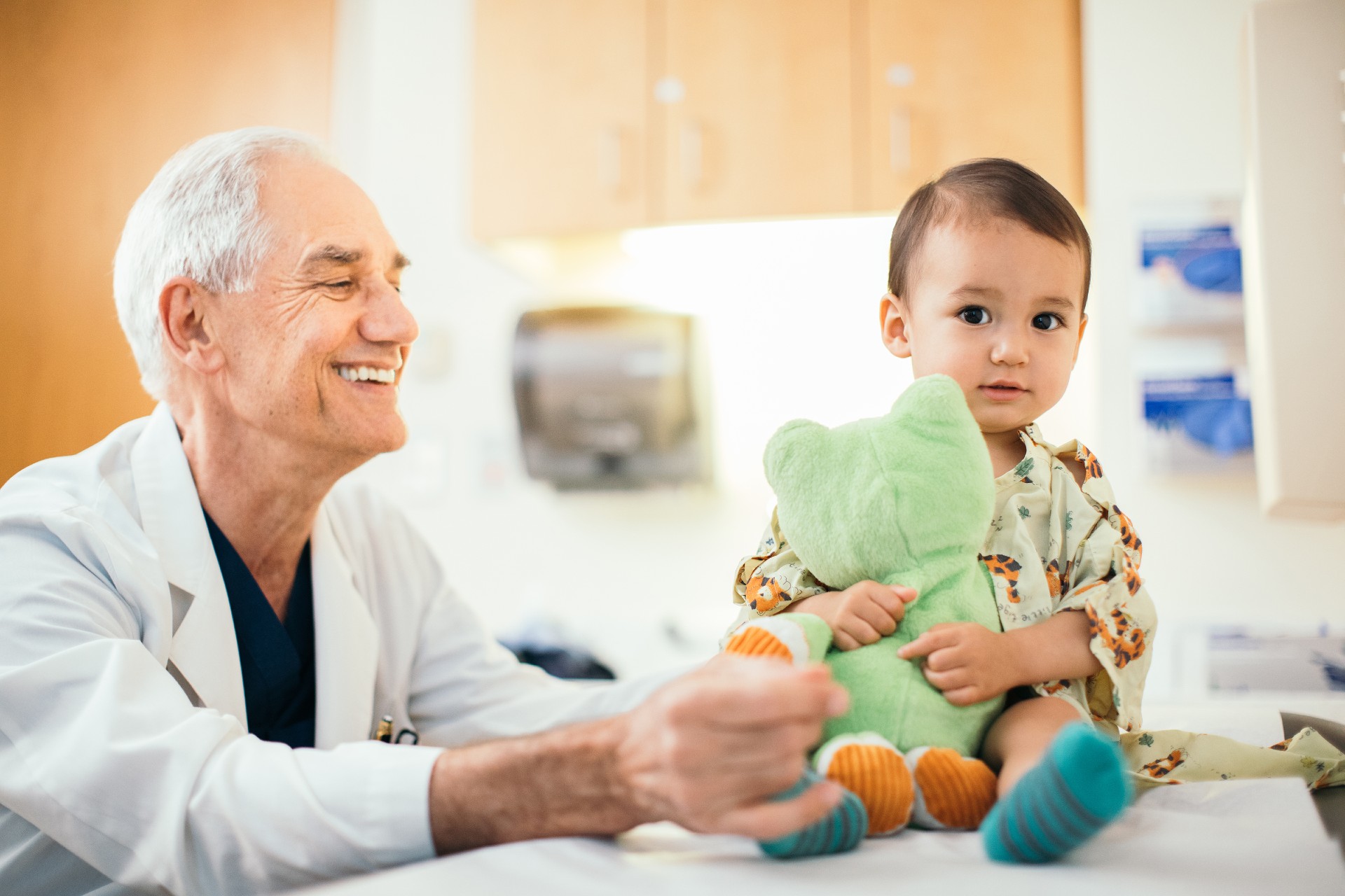 A Cardiologist with a Baby Patient sitting in exam room.